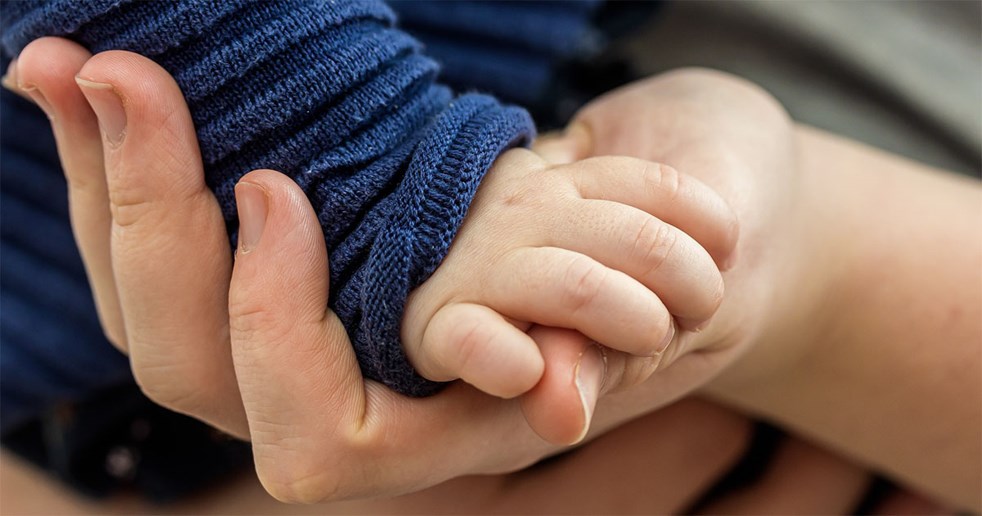 Ett barns hand håller i en vuxens hand